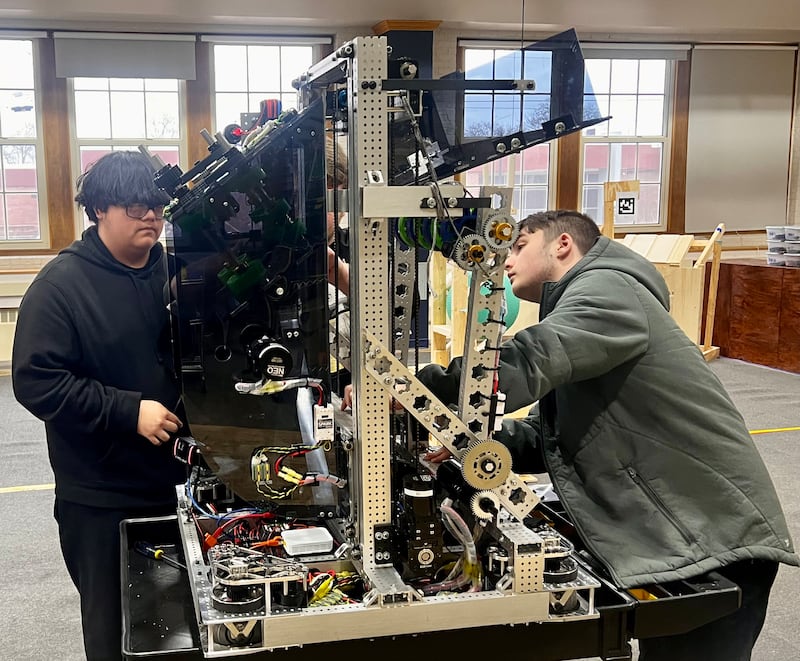 Sterling High School robotics team members Manuel Mejia, Brevin Folsom and Austin Fox work on the team's robot.