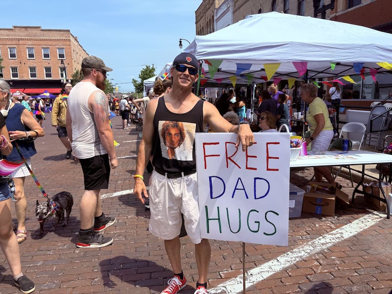 Mike DeCicco holds up a "Free Dad Hugs" sign during Woodstock PrideFest June 15, 2025.