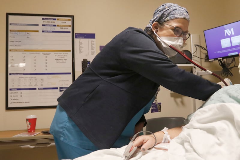 Dr. Linda Furlan assesses a patient in the emergency room of Northwestern Medicine McHenry Hospital on Thursday, Dec. 22, 2022. A spike in RSV, the flu and COVID-19 have caused hospitals to fill up and change their course to deal with the influx of illness.