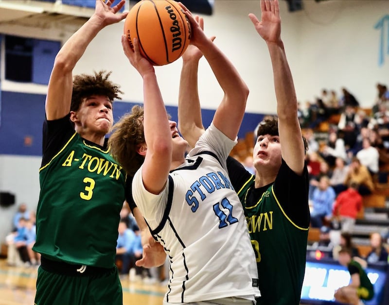 Bureau Valley's Blake Foster powers up against Abingdon-Avon's Tre Kenon (3) and Lucas Andrews for a first-half shot Friday night at the Storm Cellar. A-Town won 47-45.