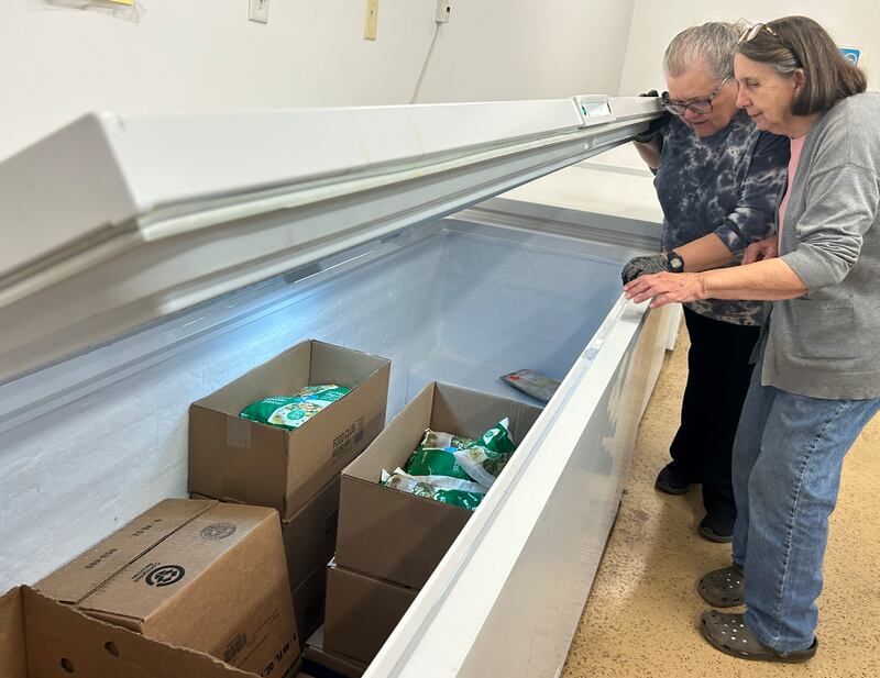Volunteers Jean Dawson and Terry Pearson check out frozen items in one of the freezers at the Polo Lifeline Food Pantry on Saturday, Nov. 15, 2025. The pantry, located at 113 Green Street, has seen an increase in clients due to the recent stoppage of SNAP benefits and federal government shutdown.