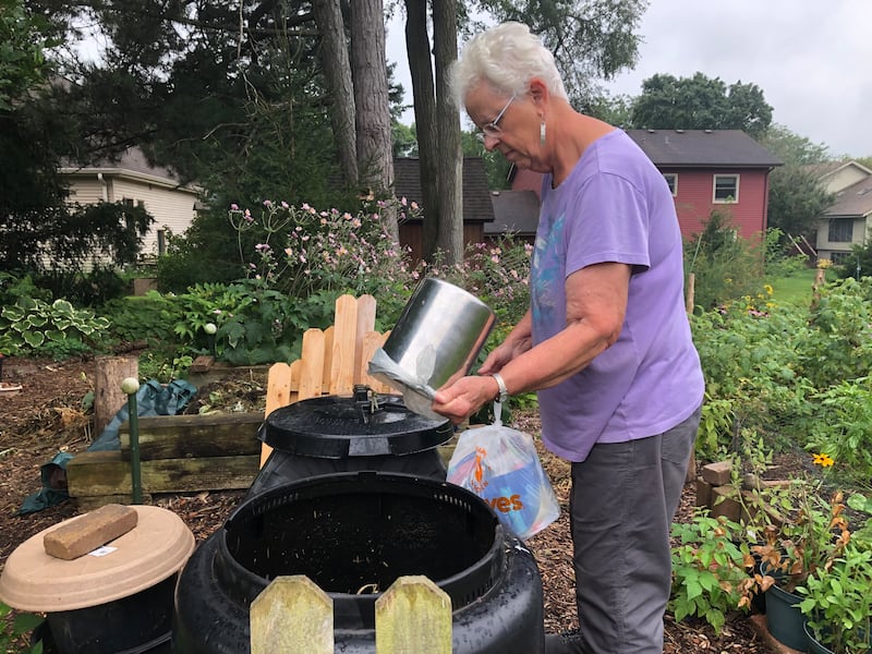 Jean Hervert Niemann of Woodstock empties a bucket into a compost bin Aug. 15, 2024.