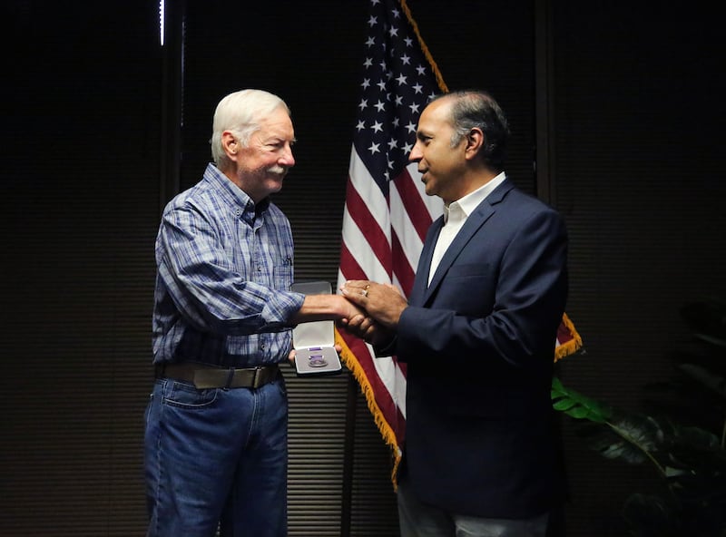 Congressman Raja Krishnamoorthi shakes Sgt. First Class Joseph Leuz's hand, after awarding him the Purple Heart Award, for his injuries received during the Vietnam War, on Friday, July 25, 2025.