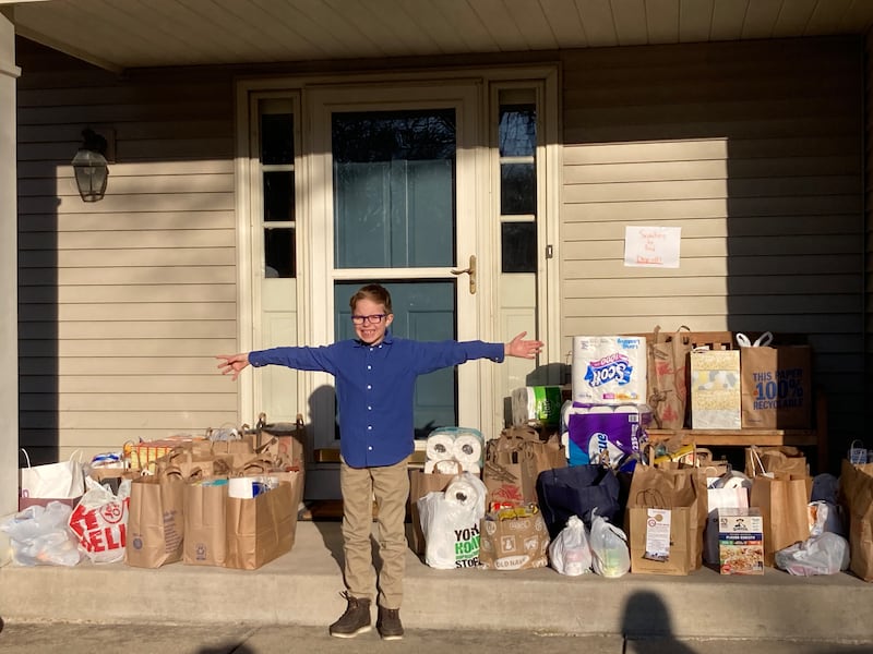 Colin Dugas of Cub Scout Pack 137 in Geneva, in front of his house where the Pack dropped off more than 600 pounds of food. The donations were given to St. Peter Food Pantry in Geneva as part of Three Fires Council Scouting for Food service project.