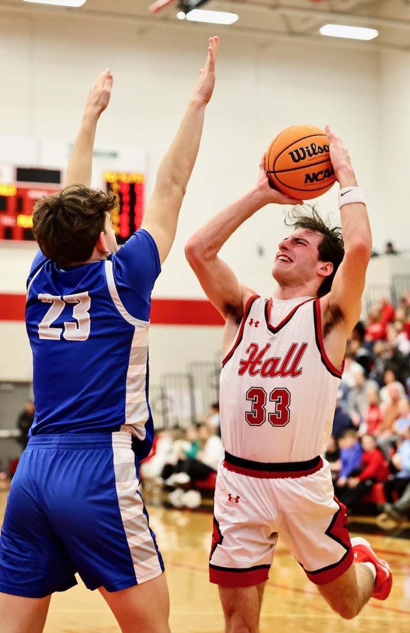Hall senior Braden Curran shoots over Princeton's Hayden Sayler in the first half of Friday's Three Rivers game in Spring Valley. The Red Devils rallied in the second half for a 57-51 victory.