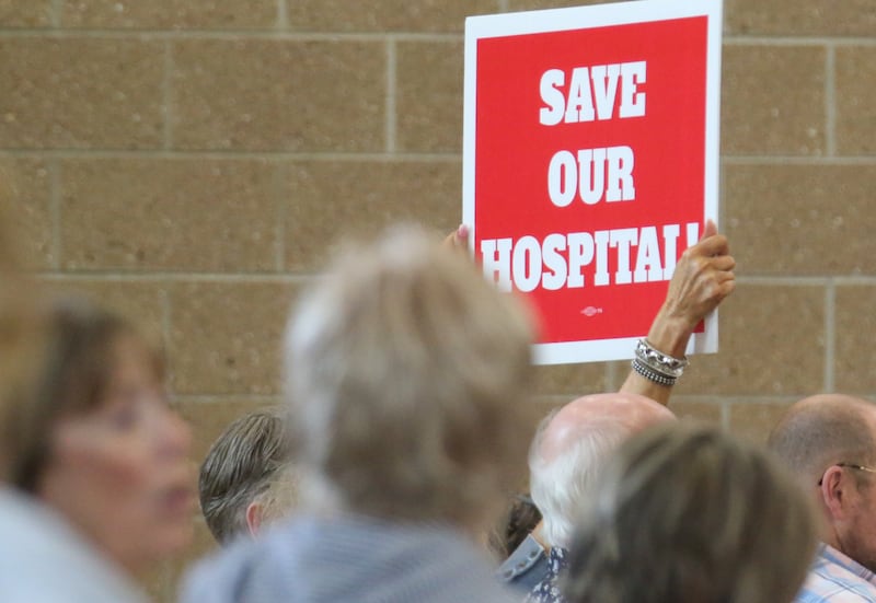 A crowd member holds a sign that reads "Save Our Hospital" during a public hearing regarding OSF St. Elizabeth Hospital's plans to reduce services on Tuesday, June 10, at Central Intermediate School in Ottawa.