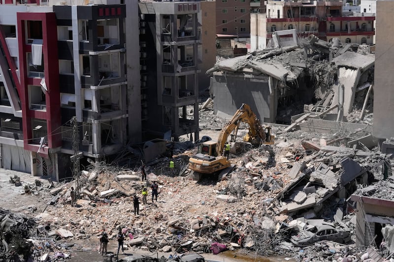Rescue workers use an excavator, as they search for victims under the rubble of a building that was hit Monday in an Israeli airstrike in the southern port city of Tyre, Lebanon, Tuesday, June 2, 2026. (AP Photo/Mohammed Zaatari)