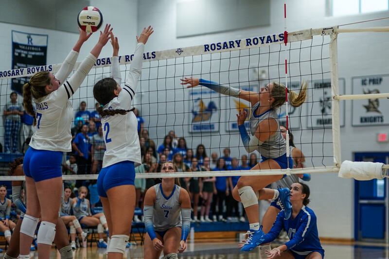 St. Charles North's Amber Czerniak (right) hits the ball off a kill attempt past the Rosary’s Emily Toepper (7) and Charlotte Blankenheim (2) for a score during a volleyball game at Rosary High School in Aurora on Monday, Aug 25, 2025.