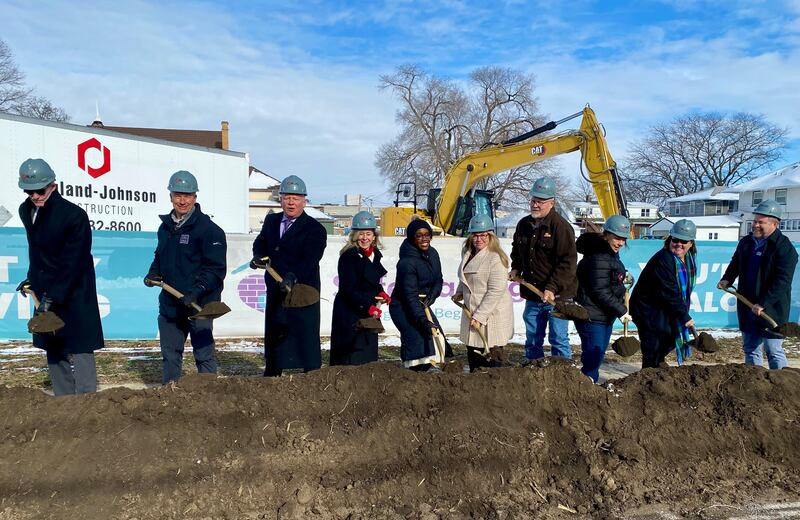 DeKalb area officials including elected leaders, staff and supporters of Safe Passage Inc., pose for a group photo on Friday, Dec. 5, 2025, at the agency's ceremonial groundbreaking to mark the start of construction on a new domestic violence survivor shelter at 217 Franklin St., in DeKalb.