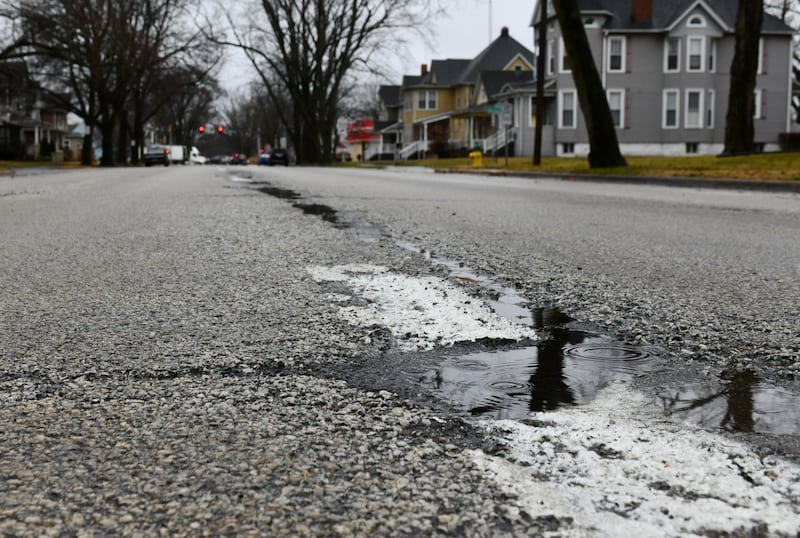 Rain puddles in the potholes along South Indiana Avenue in Kankakee in January 2023.