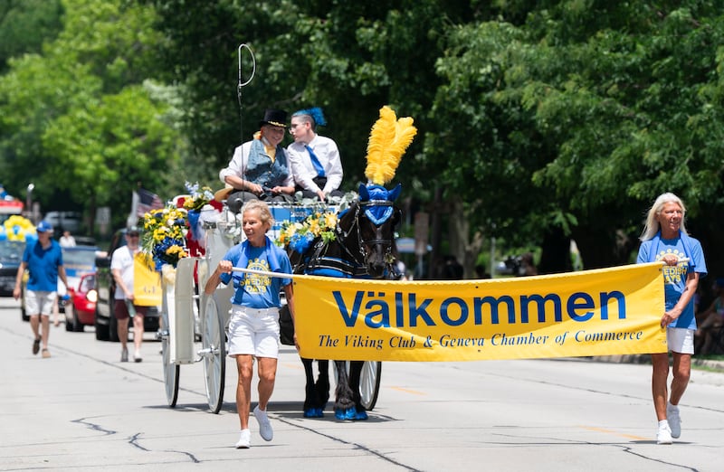 Volunteers Carol Smith, left, and Diane Coughlin hold the welcome sign to start the parade on Anderson Boulevard during the 75th annual Swedish Days parade on Sunday, June 22, 2025 in downtown Geneva.  "We love Geneva, we've lived here our whole lives." Said Smith. The event, sponsored by the Geneva Chamber of Commerce, was the final event of the festival that ran June 18th-22th.