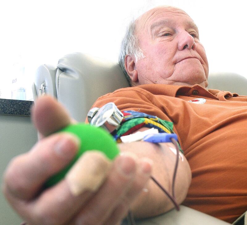 Blood donor John Hodge squeezes a ball as he waits to have enough for a full donation at the Heartland Blood Center on Tuesday, June 14, 2011.