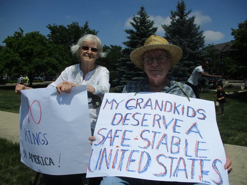 Mike Hall, a former high-school social studies teacher, and friend Clara Sweet, show their opposition to actions by the Trump administration at a demonstration outside the Timbers of Shorewood senior living center on Saturday. June 14, 2025