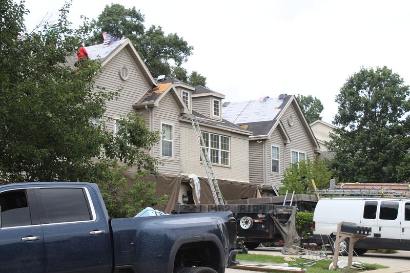 Contractors work on a roof of a Cobblestone Woods townhome on Aug. 20, 2025 in Prairie Grove.