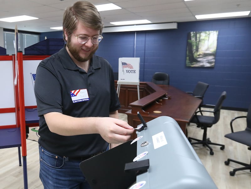 Election judge Bobby Bradish places new stickers on the ballot machine on Tuesday, April 1, 2025 at the Utica Village Hall. Bradish is a first-time election judge.