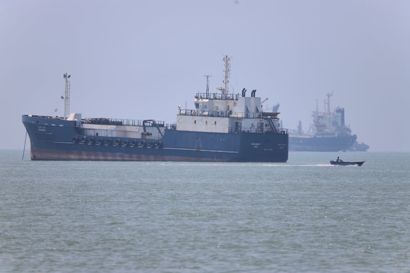 A small motorboat passes anchored vessels in the Strait of Hormuz off Bandar Abbas, Iran, Wednesday, June 17, 2026.(Amirhosein Khorgooi/ISNA via AP)