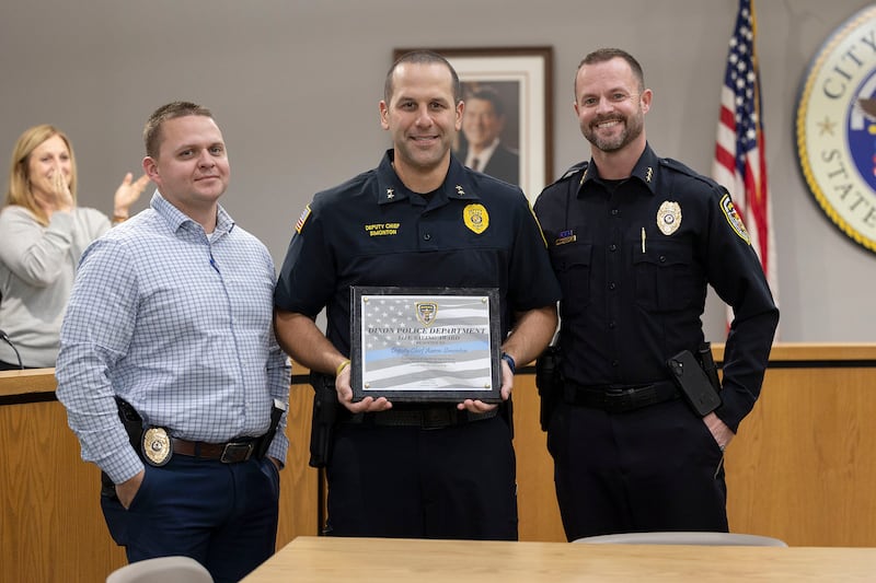 Dixon Police Sergeant Chris Scott (left) and Chief Ryan Bivins present Deputy Chief Aaron Simonton (middle) with the Life Saving Award Monday, Nov. 3, 2025, at the Dixon City Council meeting.