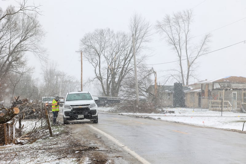 Snow falls as workers help with recovery efforts along South Sandbar Road in Aroma Township on March 16, 2026, following the March 10 tornado in Kankakee County.