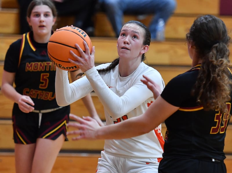 Minooka’s Madelyn Kiper goes to the basket between two Montini defenders during a Montini Christmas Tournament game on December 22, 2025 at Montini Catholic High School in Lombard.