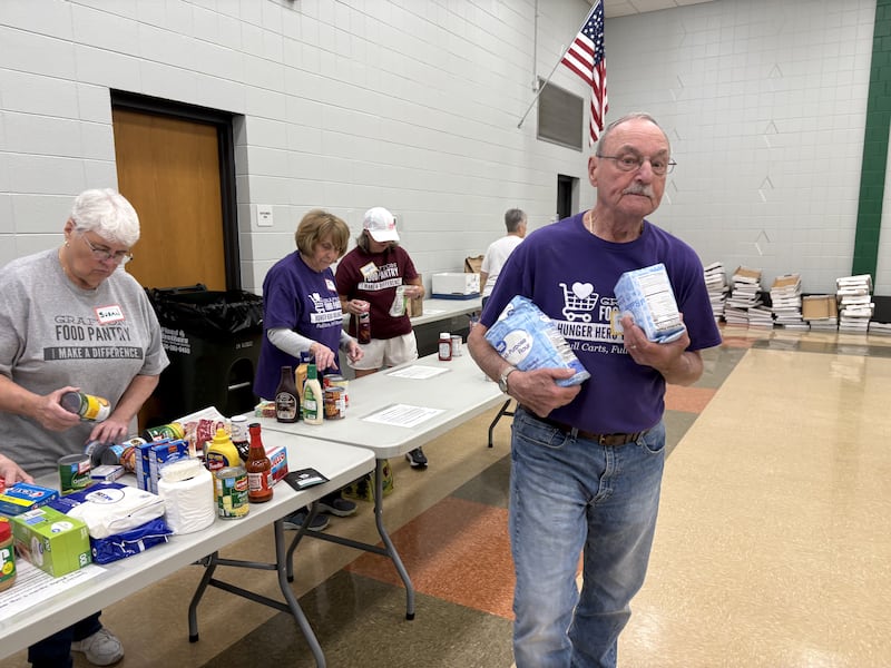 Grafton Food Pantry Volunteer Pete Schilling grabs bags of sugar at the Huntley Park District Saturday May 9, 2026.
