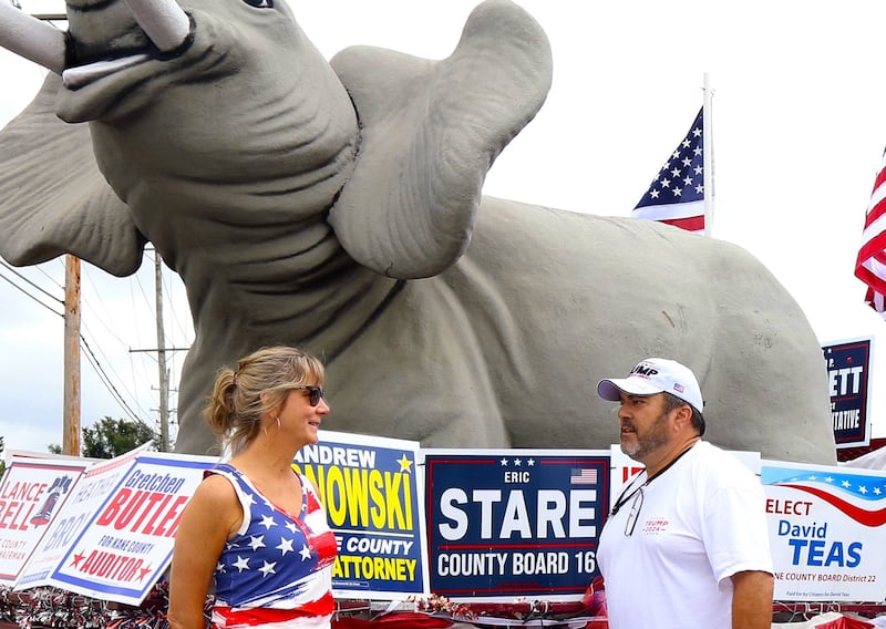 Andro Lerario (right), chairman of the Kane County Republicans, chats with Vice Chairman/SecretaryPamela Carr (left) on Sunday, Aug. 18, 2024 in Lily Lake before participating in a caravan to a rally in Woodstock.