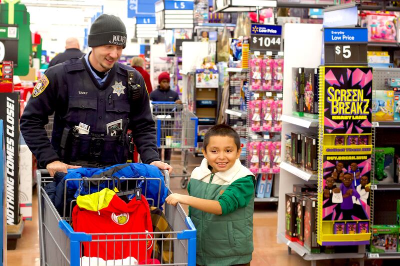 Joliet Police Officer Sean Early shops with a child during the 36th annual Santa's Cops event on Saturday, Dec. 6, 2025, at Walmart, 401 Illinois Route 59, in Shorewood.