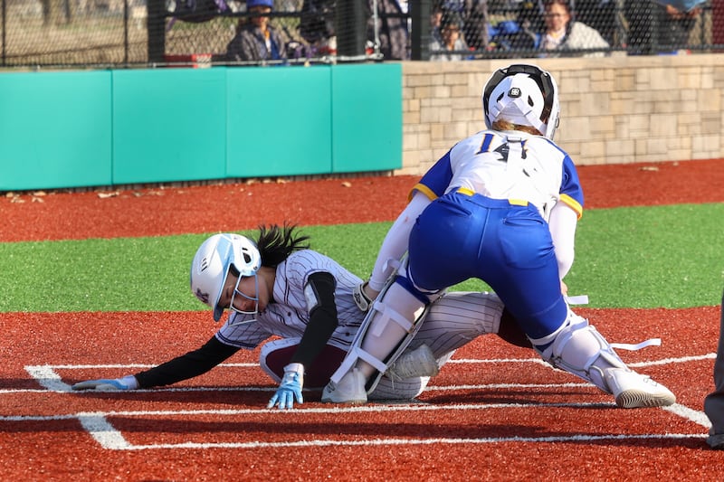 Kankakee's Lily James scores a run against Crete-Monee's Madison Myers at the plate during the Kays 20-11 loss to Crete-Monee on Tuesday, April 7, 2026.