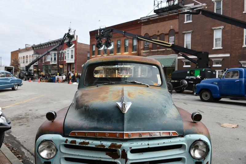 Old cars line East Washington Street in downtown Momence as a film crew works on the set of Netflix's Monster series on Feb. 11, 2025.