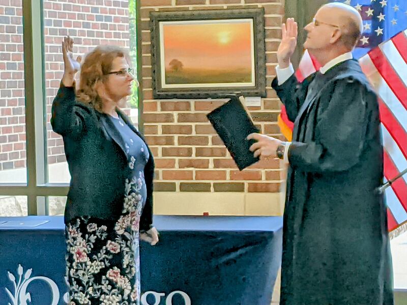 Kendall County Judge Stephen Krentz, right, administers the oath of office to new Oswego Village Trustee Jennifer Hughes, left, prior to the May 6 Oswego Village Board meeting.