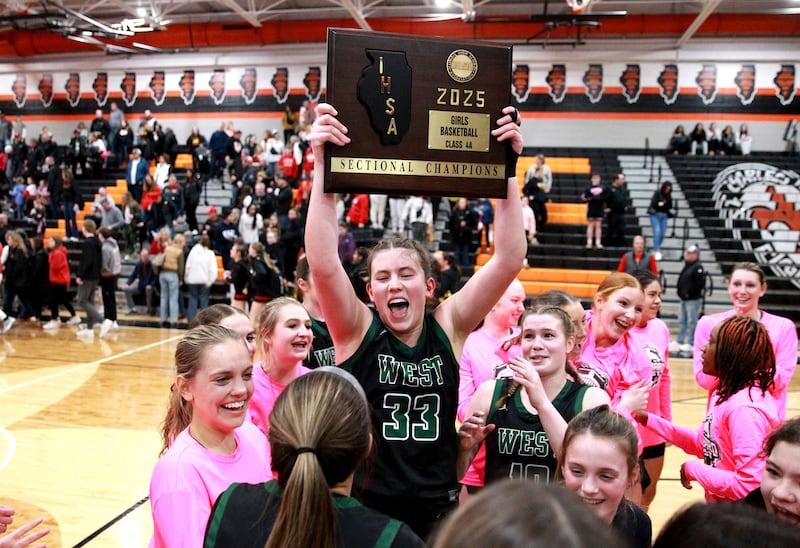 Glenbard West's Makenna Yeager holds up the team’s plaque following their Class 4A St. Charles East Sectional final over Batavia on Thursday, Feb. 27, 2025 in St. Charles.