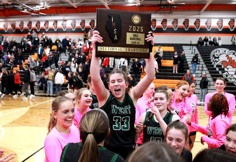 Glenbard West's Makenna Yeager holds up the team’s plaque following their Class 4A St. Charles East Sectional final over Batavia on Thursday, Feb. 27, 2025 in St. Charles.