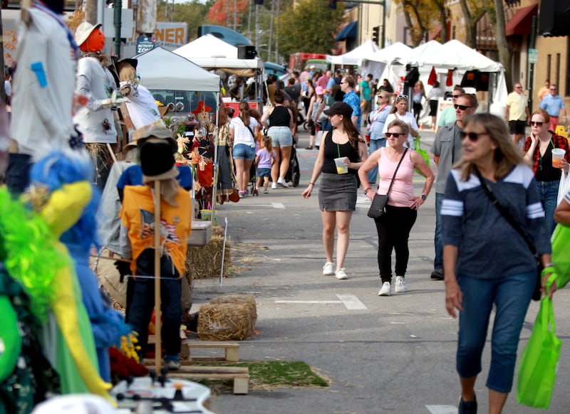 Spectators look at some of the scarecrows on display along Riverside Avenue on Friday, Oct. 11, 2024 during Scarecrow Weekend in downtown St. Charles.