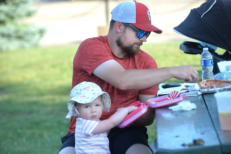 Nate White and his daughter, Macie, 18 months, of Polo, enjoy a bite to eat at the River's Edge Farmers Market in Oregon on Thursday, June 19, 2025. The Farmers Market is held Thursday nights 5-7:30 p.m. at 123 N. 2nd St., in Oregon. It includes vendor and food booths and entertainment.