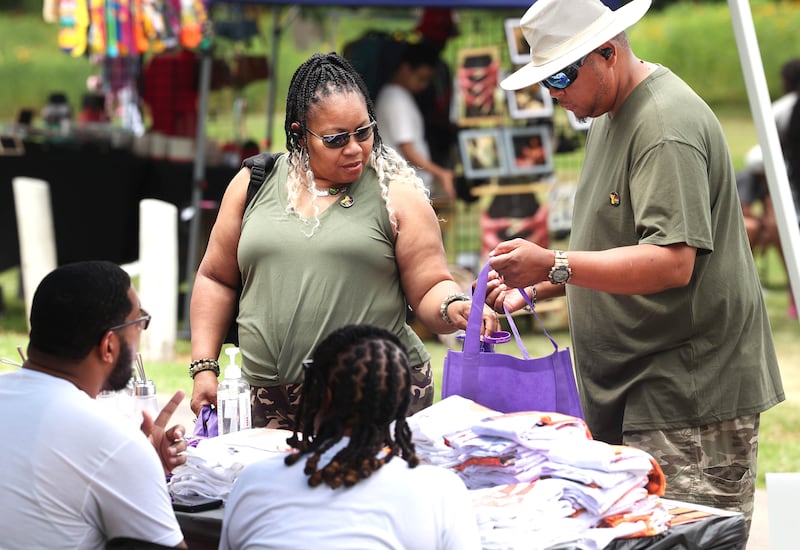 Visitors stop by one of the booths during the Juneteenth Community Celebration Saturday, June 15, 2024, at Hopkins Park in DeKalb.