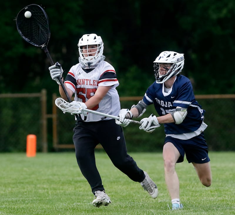 Huntley's Anthony Taylor passes the ball as he is guarded by Cary-Grove's Evan Lamb during the Marian Central Sectional boys lacrosse semifinal match on Wednesday, May 28, 2025, at Marian Central High School in Woodstock.