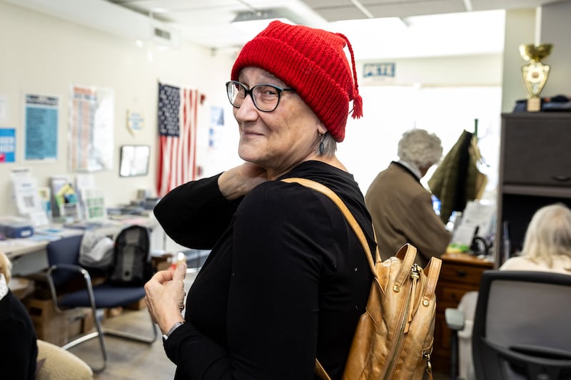 Downers Grove resident Emily Friel models a finished hat Sunday during the Melt the ICE Hat Knit-Along event at the Downers Grove Township Democrats Organization office