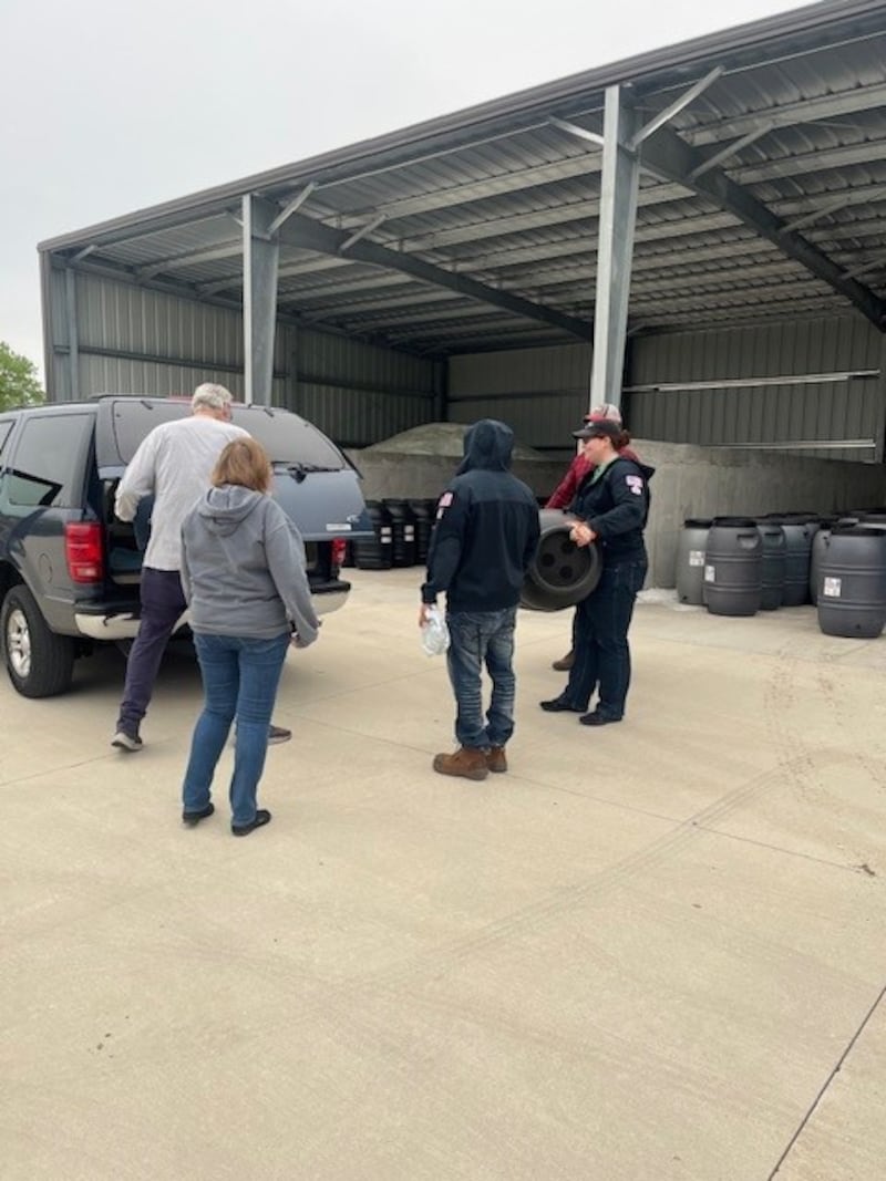 Morris Public Works loads rain barrels into residents' vehicles.