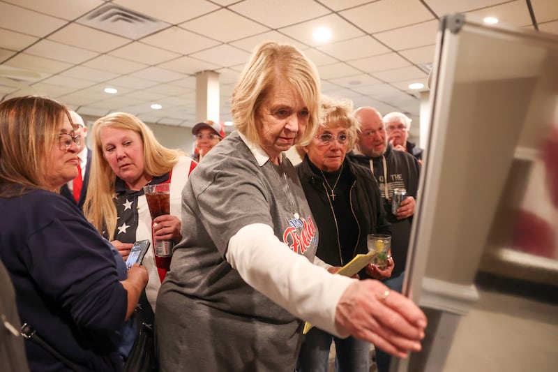 Surrounded by fellow Manteno Freedom Party candidates and supporters, Manteno mayor-elect Annette LaMore reviews vote totals on Tuesday night during at a watch party at the Manteno American Legion.