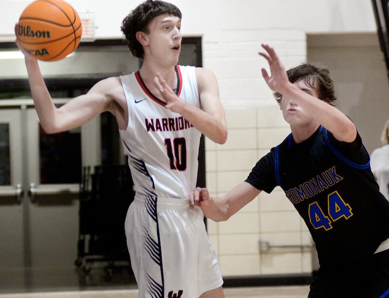 Woodland’s Jaron Follmer looks to get a pass away from the block attempt by Somonauk’s Tristan Reed in the 1st period Wednesday at Woodland.