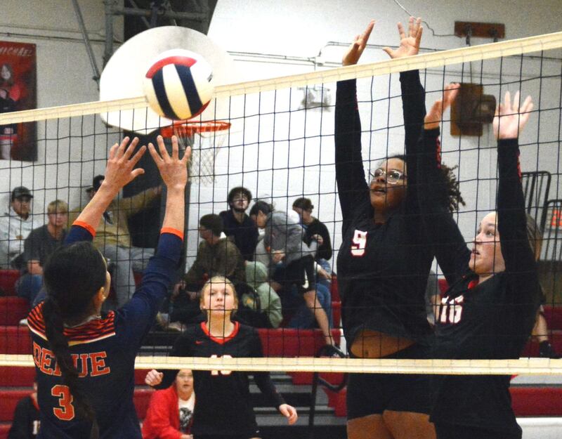 LaMoille's Olivia Glasper (9) and Jena Monroe (16) defend the net as Vivian Lopez makes a play for DePue Tuesday night at Dean Madsen Gymnasium in LaMoille. The Lions won 25-20, 25-17 to notch their first win.