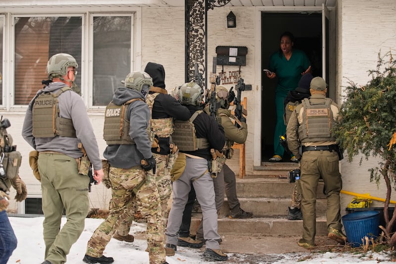 Teyana Gibson Brown, second from right, wife of Garrison Gibson, reacts after a federal immigration officer used a battering ram to break down a door before arresting Garrison Gibson, Sunday, Jan. 11, 2026, in Minneapolis. (AP Photo/John Locher)