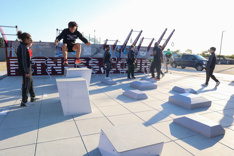Members of the Kankakee JROTC demonstrate exercises on the new public outdoor fitness court at Kankakee High School on Thursday, Oct. 16, 2025, after the ribbon cutting ceremony. The project, located near the Dr. Genevra Walters Community Center, was completed in partnership with Blue Cross and Blue Shield of Illinois and the National Fitness Campaign.
