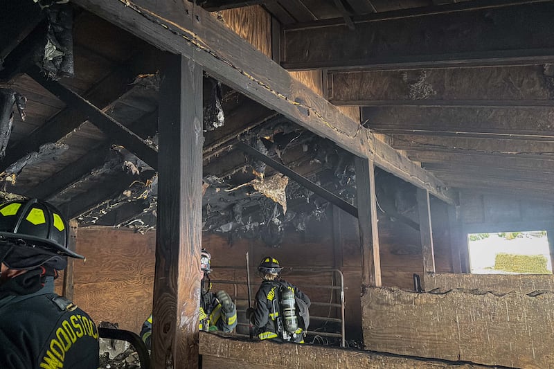The Woodstock Fire/Rescue District evaluate the damage inside a barn at the 3300 block of Stieg Road near Woodstock after a fire broke out on Dec. 10, 2025.