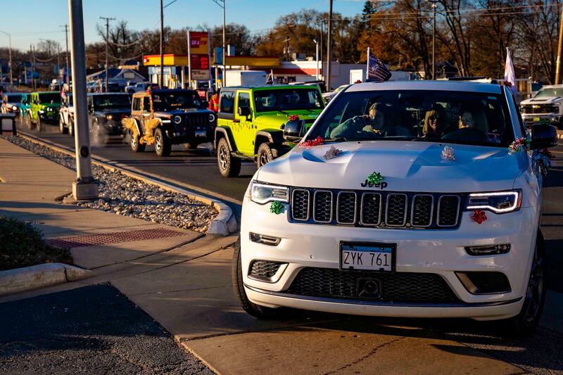 Decorated Jeeps begin to parade into the Ray Chrysler Dodge Jeep Ram parking lot in Fox Lake prior to the 2024 Jeeps on the Run Toys for Tots Run. The event has supported tens of thousands of McHenry County and Lake County families at Christmastime since its 2013 inception.