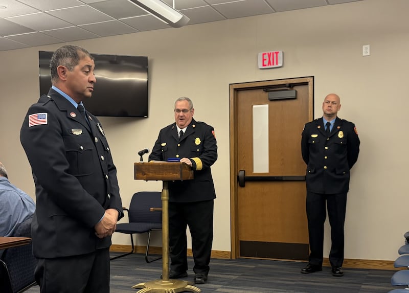 Firefighter Bill Missel receives a Lifesaving Medal from Fire Chief Gary Bird during Wednesday’s Streator City Council meeting.