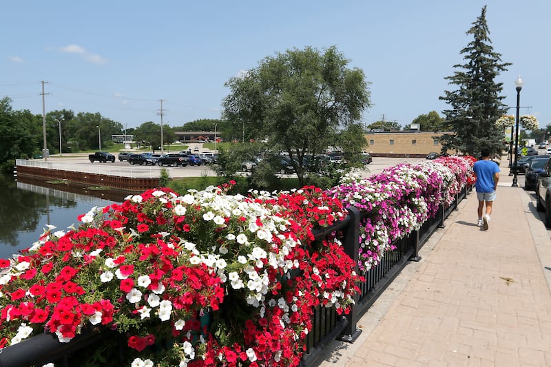 A pedestrian walks towards the 2-1/4 acres between Route 120 and Green Street that is owned by City of McHenry on Friday, July 12, 2024. Shodeen Group LLC will present to the McHenry City Council's committee of the whole their plans to develop two downtown locations. The city and Shodeen entered in a “standstill” agreement in April 2023, to not market to another developer this site or the former wastewater treatment site off Waukegan Road on the Fox River.