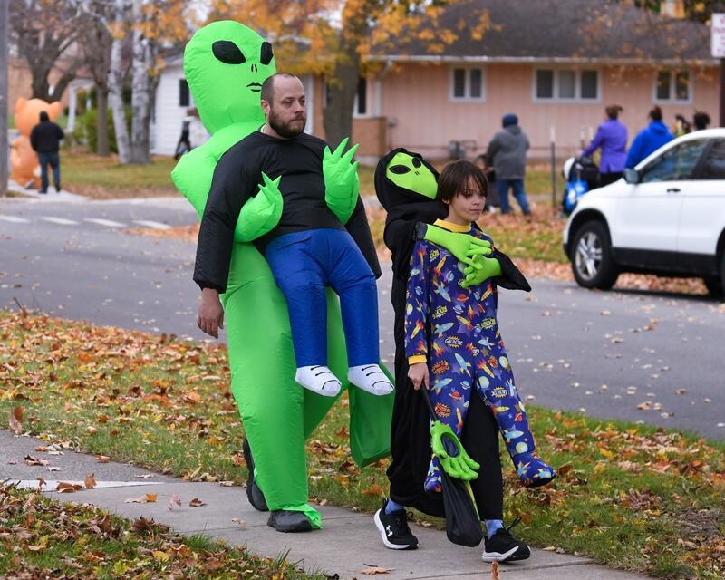 Elora Collins, 10 (right) and dad Andrew Collins go trick-or-treating for Halloween on Thursday, Oct. 31, 2024, in DeKalb.