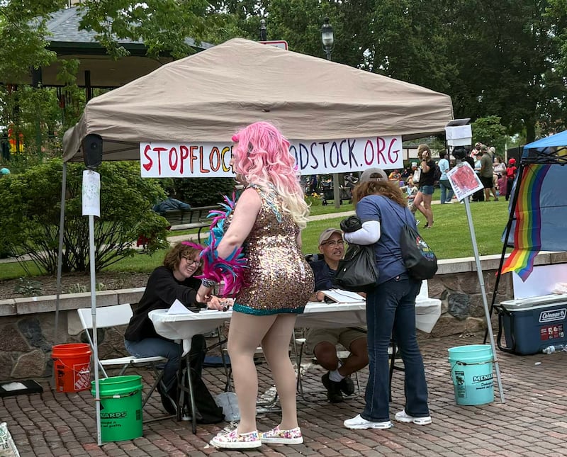 Woodstock PrideFest attendees stop by the Stop Flock in Woodstock booth at the fest, Sunday, June 14, 2026.