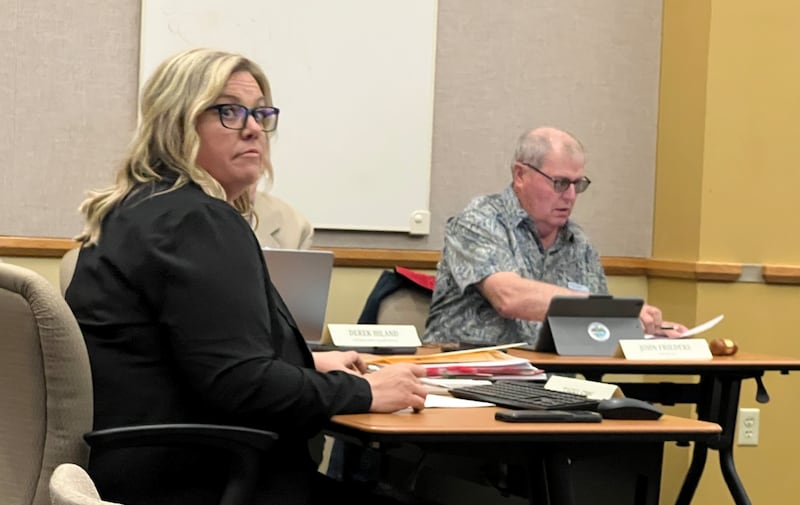 DeKalb County Clerk and Recorder Tasha Sims looks to the podium during the DeKalb County Board meeting on May 21, 2025, while DeKalb County Board Chairman John Frieders looks through county documents.