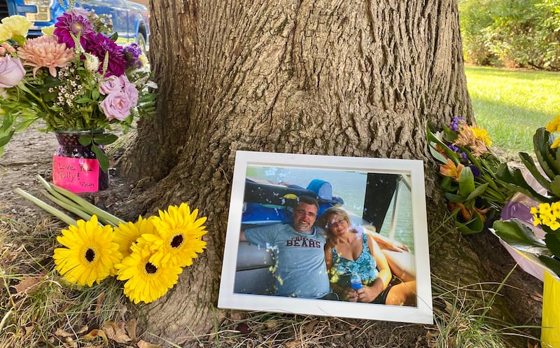 Memorial flowers, a photo and messages of love were placed outside the home of Gary Schmidt and Holly Schmidt on Friday, Oct. 3, 2025, on Oakland Drive in Sycamore. The Schmidts, shown in the photo, were found dead in their home on Tuesday, authorities said.